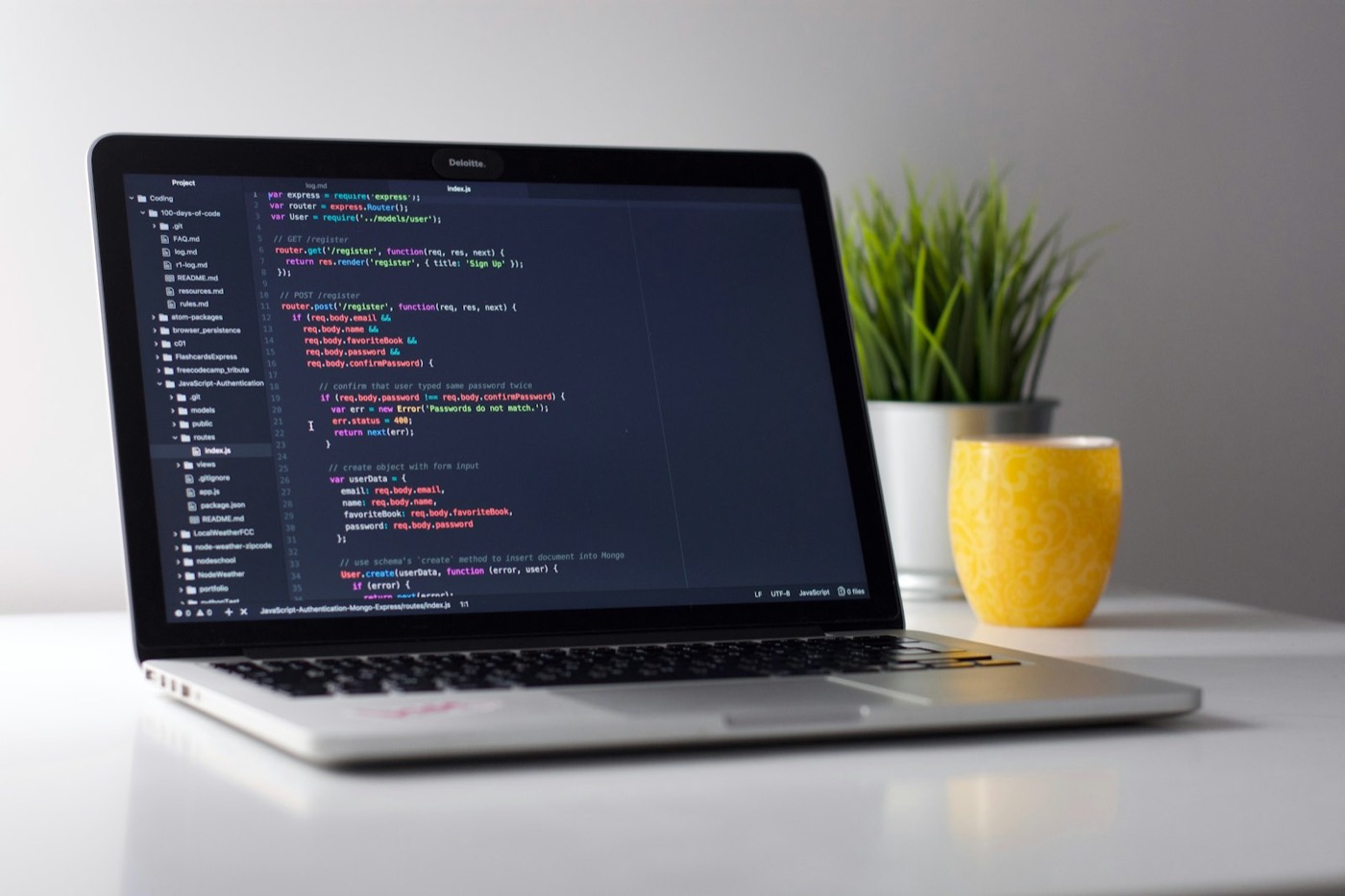 Laptop displaying code at a desk.